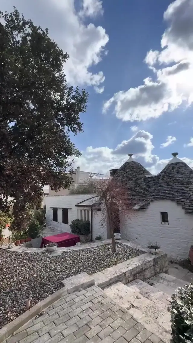 Cortile in ghiaia e pietra tra i trulli