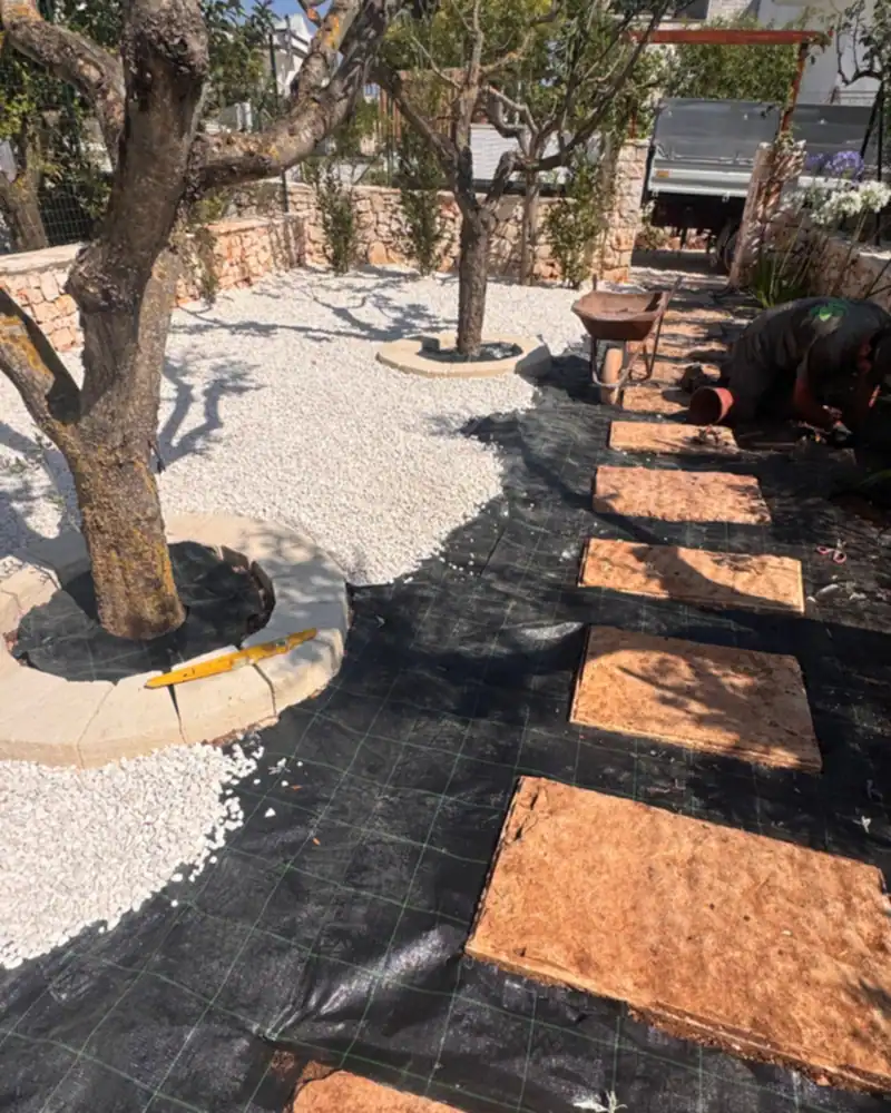 Riqualificazione di un giardino tra gli ulivi: telo pacciamante, ghiaia e lastre in pietra
